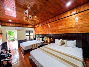 a bedroom with two beds and a wooden wall at Tam Coc Central Backpacker Hostel in Vũ Lâm +69 photos