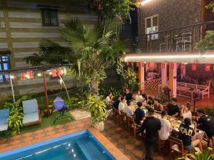a group of people sitting at a table in a restaurant at Phong Nha Dawn Home in Phong Nha