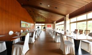 a dining room with white tables and white chairs at Jeju Tameus Golf & Village in Hahwajŏn