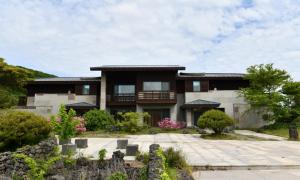 a large house with a garden in front of it at Jeju Tameus Golf & Village in Hahwajŏn