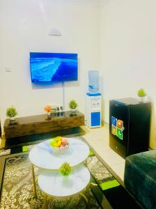 a living room with a table and a tv at Haven one bedroom in Busia
