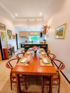 a dining room with a wooden table and chairs at Ped pool villa in Buriram