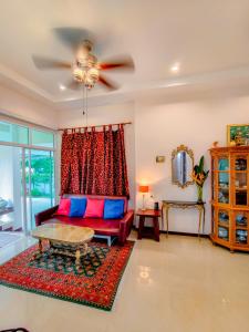a living room with a red couch and a table at Ped pool villa in Buriram +48 photos