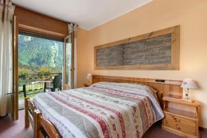 a bedroom with a bed and a large window at Hotel Valentino - Bionaz in Bionaz