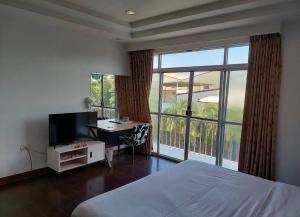 a bedroom with a bed and a desk and a large window at 一品汽車旅館 in Dounan