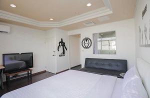 a bedroom with a bed and a flat screen tv at 一品汽車旅館 in Dounan