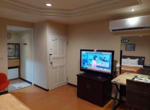 a living room with a television and a room with a bed at 一品汽車旅館 in Dounan +3 photos