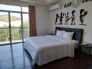 a bedroom with a large bed and a large window at 一品汽車旅館 in Dounan