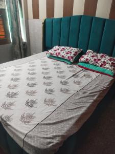 a bed with two pillows on top of it at Osween Guest House in Srinagar