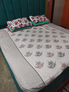a bed with two pillows on top of it at Osween Guest House in Srinagar