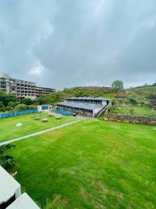 ein großes grünes Feld mit einem Gebäude im Hintergrund in der Unterkunft Hotel Raha in Udaipur