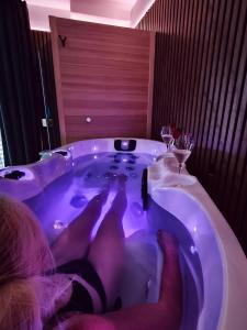 a person in a bath tub with two glasses of wine at Srnčí vrch in Batňovice