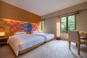 a bedroom with two beds and a desk at Hyatt Regency Kyoto in Kyoto