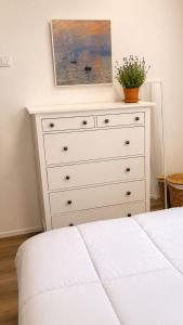 a white dresser with a painting on top of it at Dolce Risveglio in Monticello