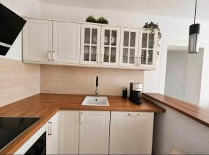 a kitchen with white cabinets and a sink at Garden Haus Livno in Livno +6 photos