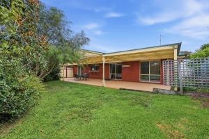 a home with a fence and a yard at Serrell by the Sea in Inverloch