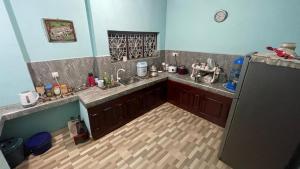 a kitchen with a sink and a refrigerator at Reefside mount villa in Deniyaya