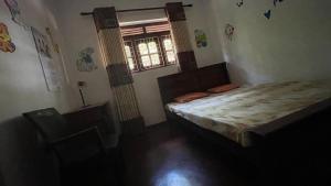 a small bedroom with a bed and a window at Reefside mount villa in Deniyaya