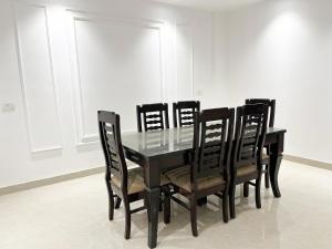 a dining room table with black chairs and a black table and a window at Hotel fabulous - Malviya Nagar in New Delhi