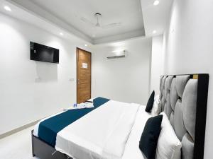 a bedroom with a bed and a tv on the wall at Hotel fabulous - Malviya Nagar in New Delhi +18 photos