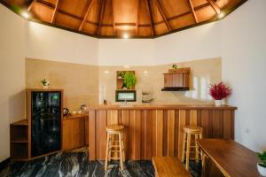 a kitchen with a bar and stools in a room at de Bintan Villa in Tenaga