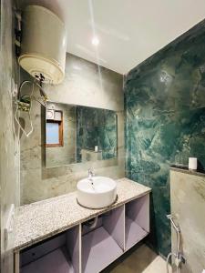 a bathroom with a sink and a green wall at Hotel fabulous - Malviya Nagar in New Delhi