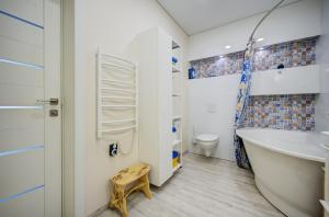 a bathroom with a tub and a sink and a toilet at Pavilnis house in Vilnius
