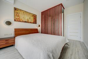 a bedroom with a white bed and a painting on the wall at Pavilnis house in Vilnius +18 photos