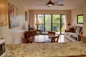 a kitchen and living room with a table and chairs at Kihei Akahi C308 in Wailea