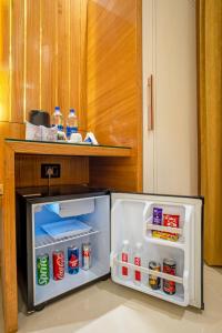 an open refrigerator with food and drinks in it at The Delhi Star Hotel near Connaught Place- New Delhi in New Delhi