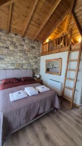 a bedroom with a bed with two towels on it at Stone Loft Suite in Karpenisi