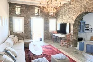 a living room with a couch and a stone wall at Villa Tina in Arnados
