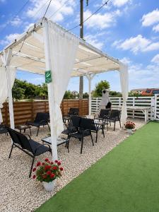 a white pavilion with chairs and flowers on a lawn at Casute tip A costinesti in Costinesti