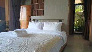 a bed with white sheets and pillows in a bedroom at Taluna Villas in Panglao Island +12 photos