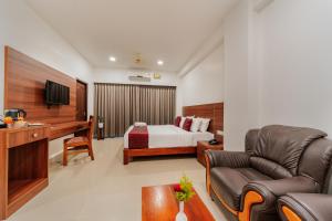 a hotel room with a bed and a couch at Hotel Sandra Palace in Thekkady
