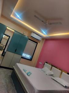 a bedroom with a large white bed and a pink wall at ks grand function hall in Jāmb