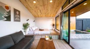 a living room with a couch and a bed and a tub at THUNWA the CAMPSITE in Ban Khao Ya Nua