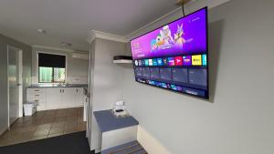 a large flat screen tv hanging on a wall at Jefferys Motel in Toowoomba