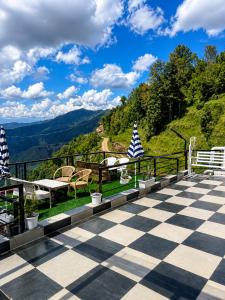 a view from the deck of a house with a checkered floor at Rumuk Boutique Resort - Offbeat escape in Dhanaulti