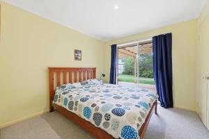 a bedroom with a bed and a window at Serrell by the Sea in Inverloch