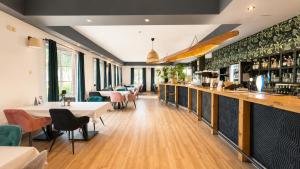 a restaurant with tables and chairs and a bar at Hotel Ukiel Wellness & SPA in Olsztyn