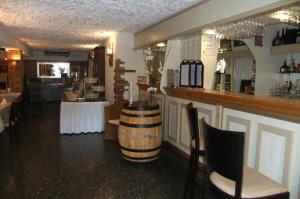 a restaurant with a bar with a wine barrel on the counter at Hôtel U Pozzu in Sisco