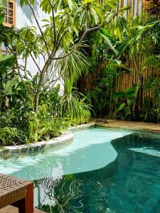 a swimming pool in the middle of a garden at Haku - Japandi Village in General Luna
