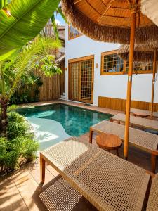 a swimming pool with chairs and an umbrella at Haku - Japandi Village in General Luna +29 photos