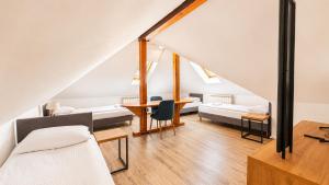 a attic room with a bed and a table at Hotel Ukiel Wellness & SPA in Olsztyn
