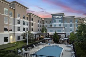 an exterior view of a hotel with a swimming pool at Homewood Suites Mobile in Mobile
