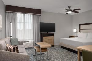a hotel room with a bed and a flat screen tv at Homewood Suites Mobile in Mobile +14 photos