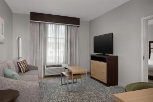 a living room with a couch and a tv at Homewood Suites Mobile in Mobile