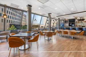 a restaurant with tables and chairs and large windows at Radisson Blu Fargo in Fargo