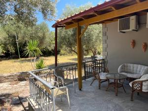 a patio with chairs and a table on a porch at O' Kipos in Mythimna